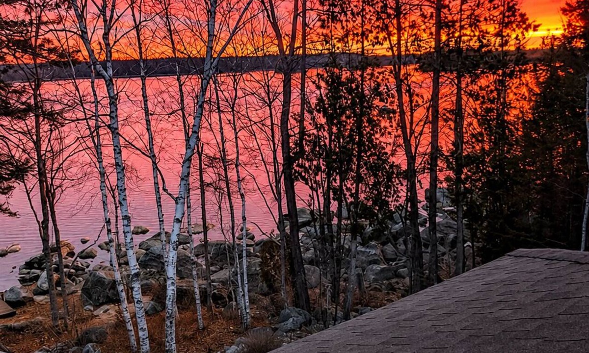 Ellsworth House | Stunning lakefront home with serene outside sitting area overlooking the water.