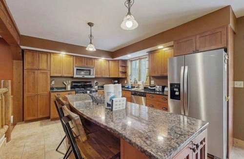 Sunday River Area House | Beautiful log cabin with nearby skiing, large living spaces, and outdoor patio