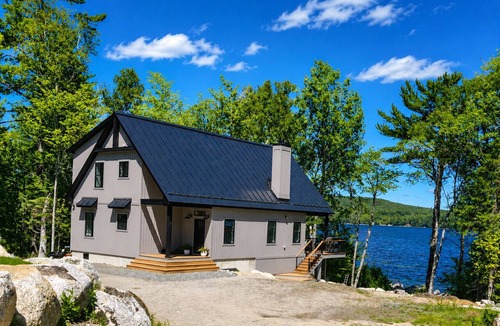 Ellsworth House | Stunning lakefront home with serene outside sitting area overlooking the water.