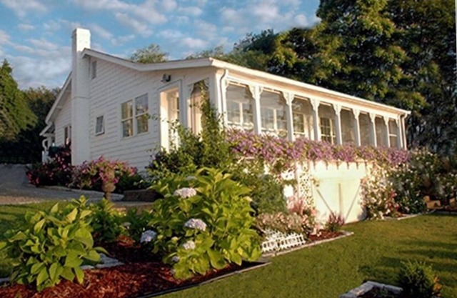 Old fashioned designer front porch living by the sea with expansive water views.